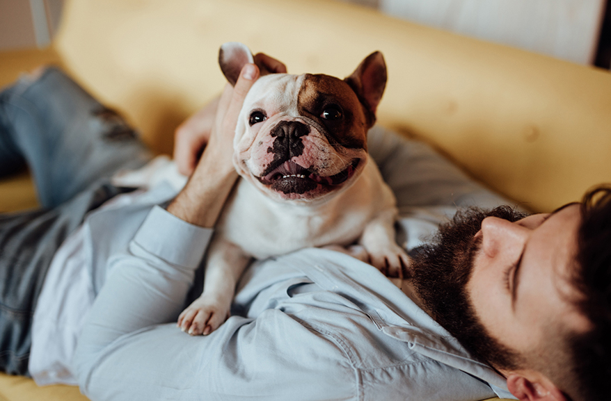 Man cuddling a small dog